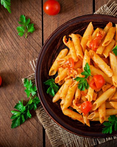 penne-pasta-tomato-sauce-with-chicken-tomatoes-wooden-table-min
